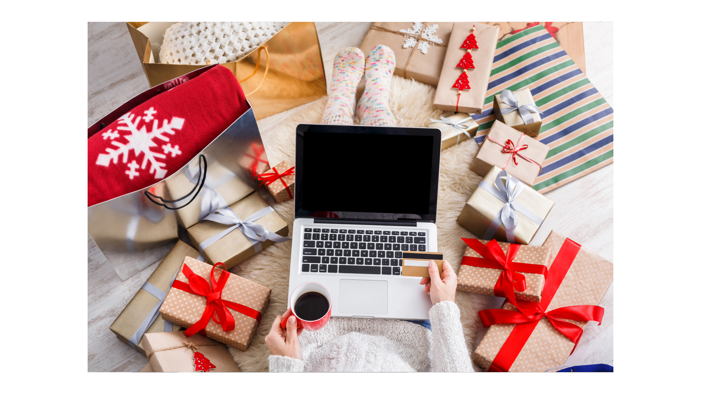 Person sitting with a computer amid many wrapped gifts